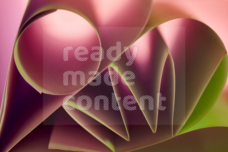 عرض فني لطيات الورق تخلق مزيج من الأشكال الهندسية، مضاءة بإضاءة ناعمة بدرجات اللون الأخضر والأحمر