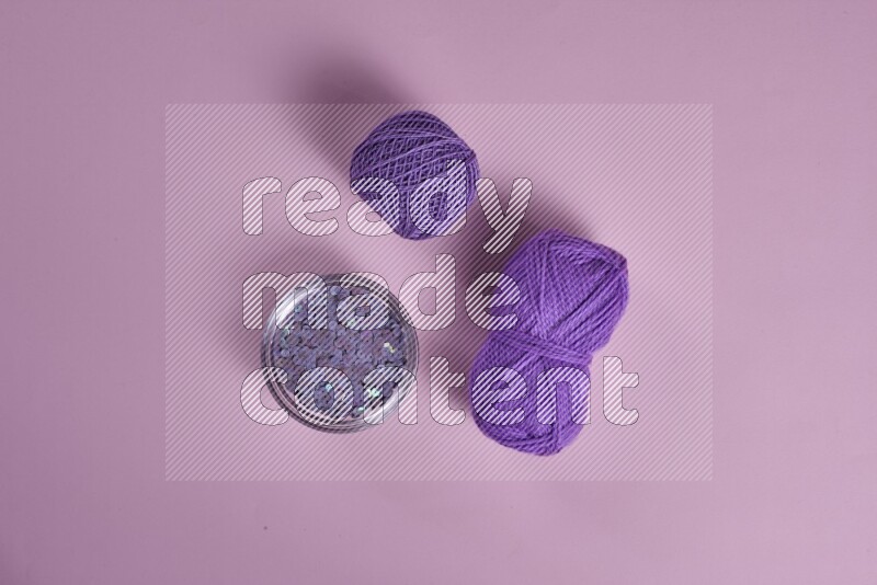 مجموعة من أدوات الخياطة والتفصيل أرجوانية وزهرية اللون على خلفية زهرية