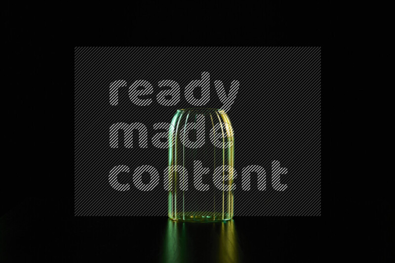 Glassware with rim light in green and yellow against black background