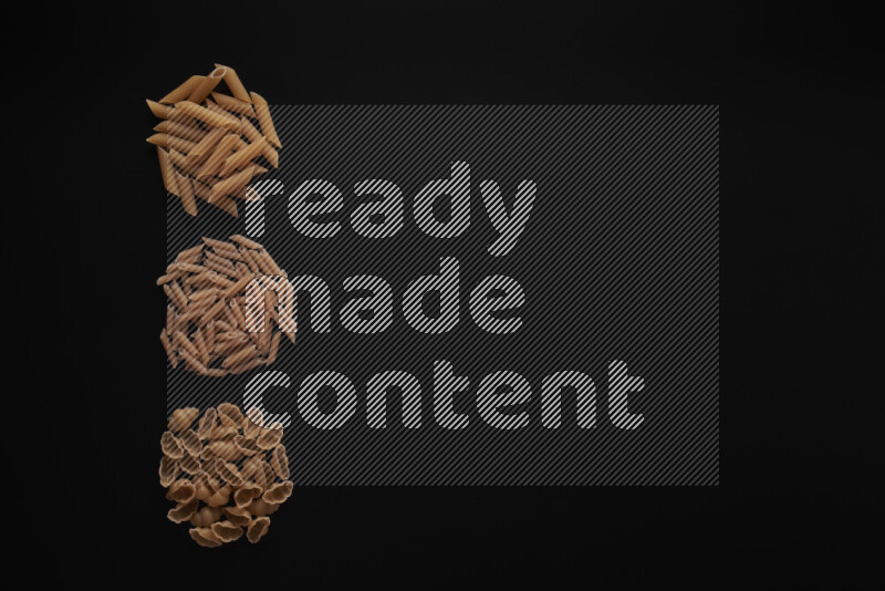 Different pasta types in 3 bunches on black background