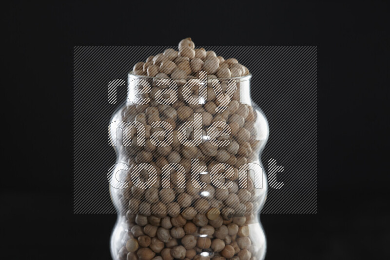 Chickpeas in a glass jar on black background