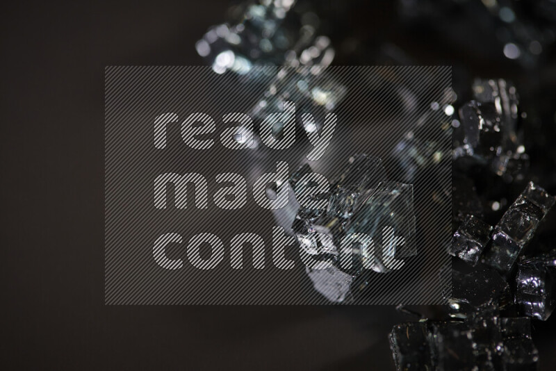 Transparent black fragments of glass scattered on a black background