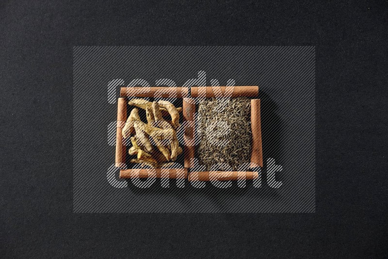 2 squares of cinnamon sticks full of cumin and turmeric fingers on black flooring