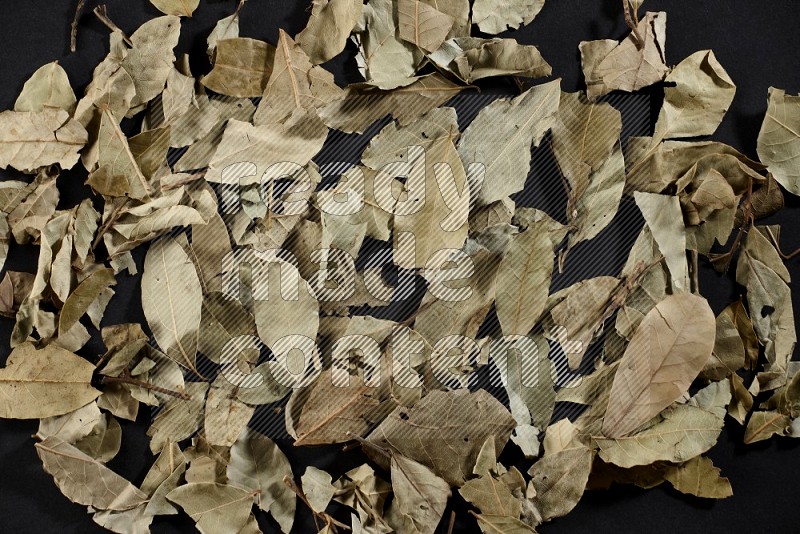Dried bay leaves on black flooring