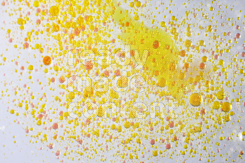 Close-ups of abstract yellow and red watercolor drops on oil Surface on white background