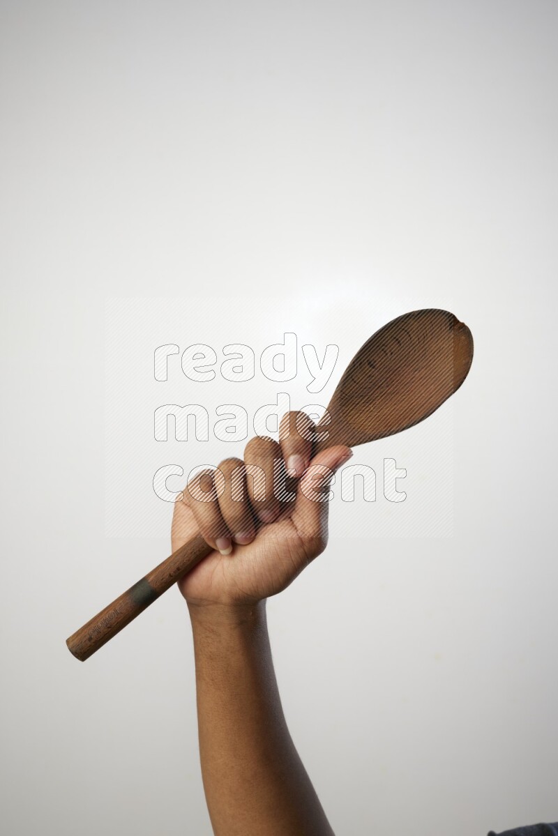 Male Hand Holding Wooden spoon on white background