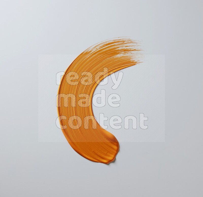 An orange half circular painting brush stroke on white background