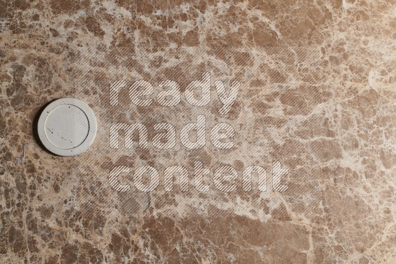 A decorative coaster on beige marble background