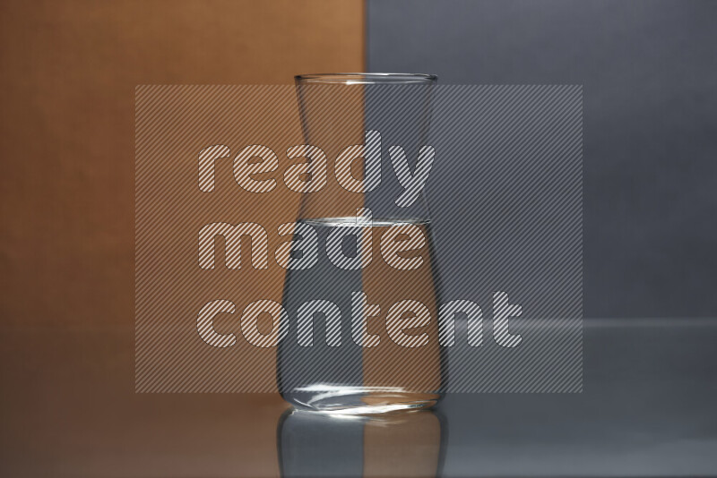 The image features a clear glassware filled with water, set against brown and dark blue background