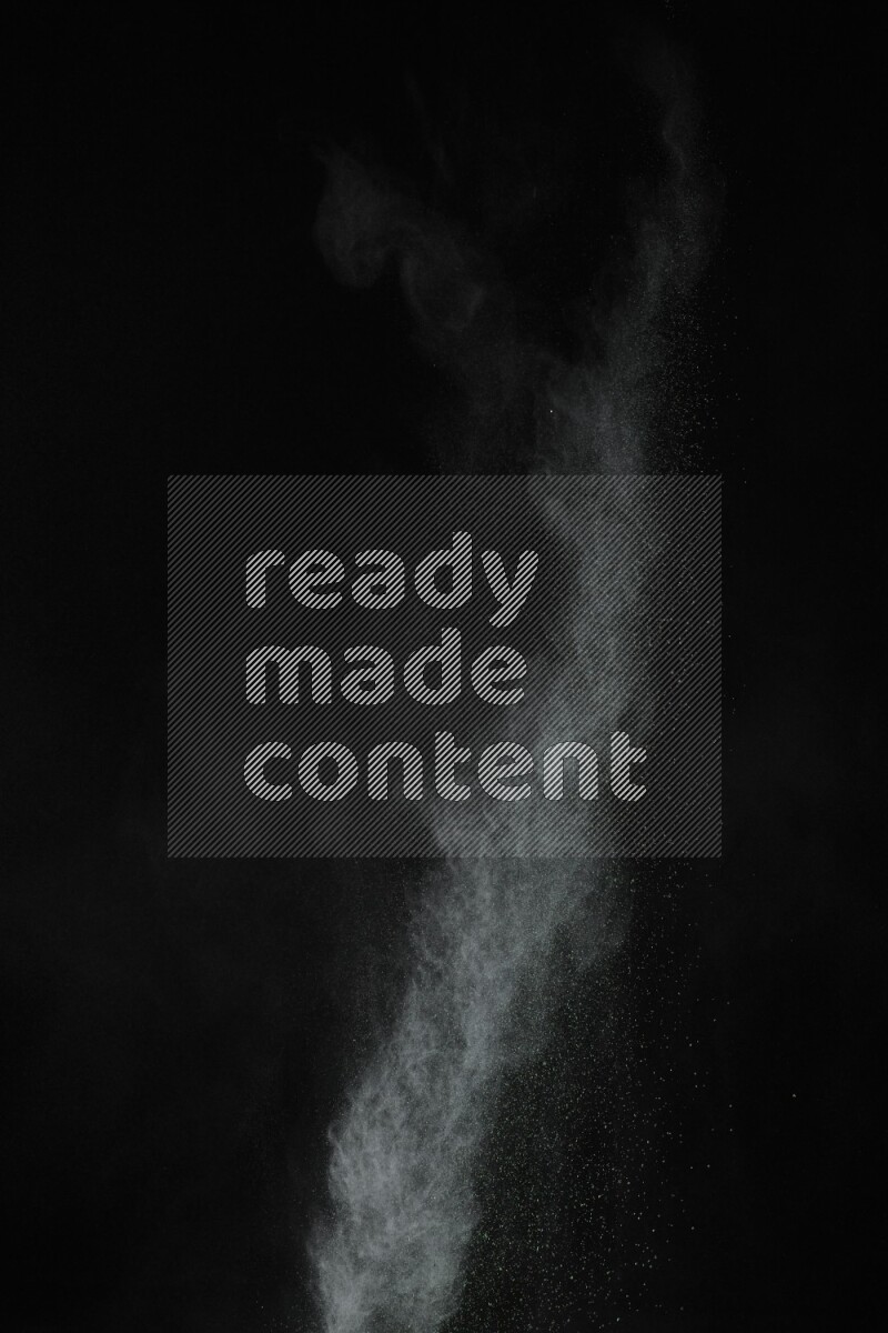 A side view of green powder explosion on black background