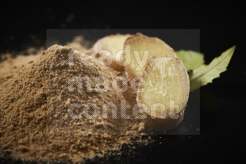 A bunch of ground ginger powder on black background