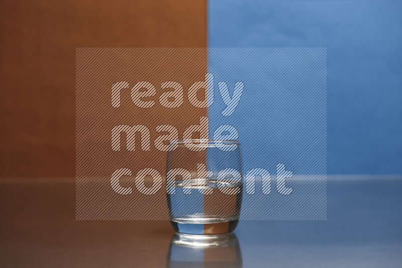 The image features a clear glassware filled with water, set against brown and blue background