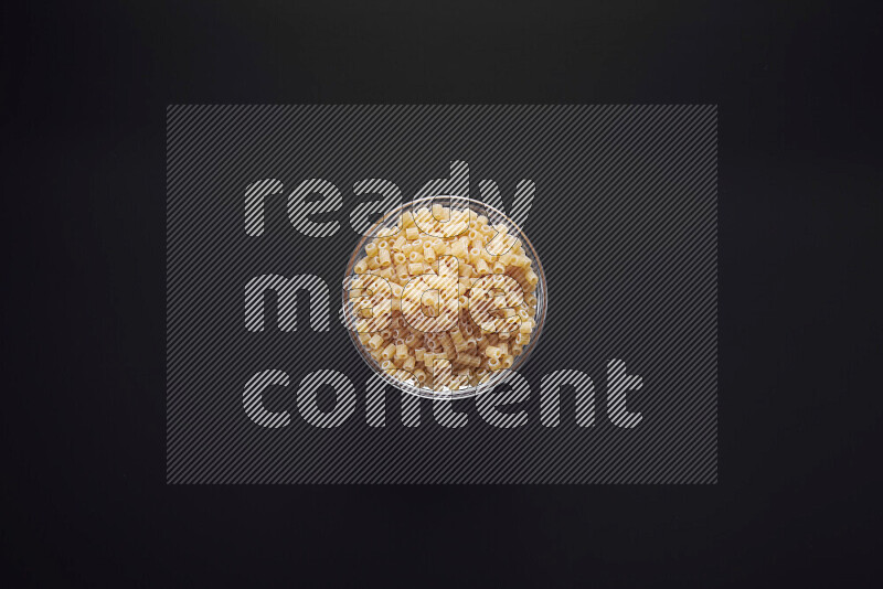 Small rings pasta in a glass bowl on black background