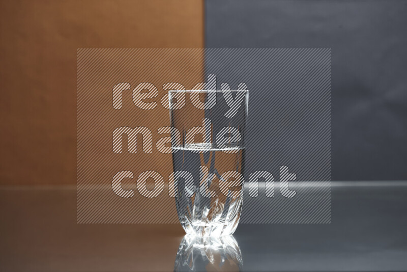 The image features a clear glassware filled with water, set against brown and dark blue background