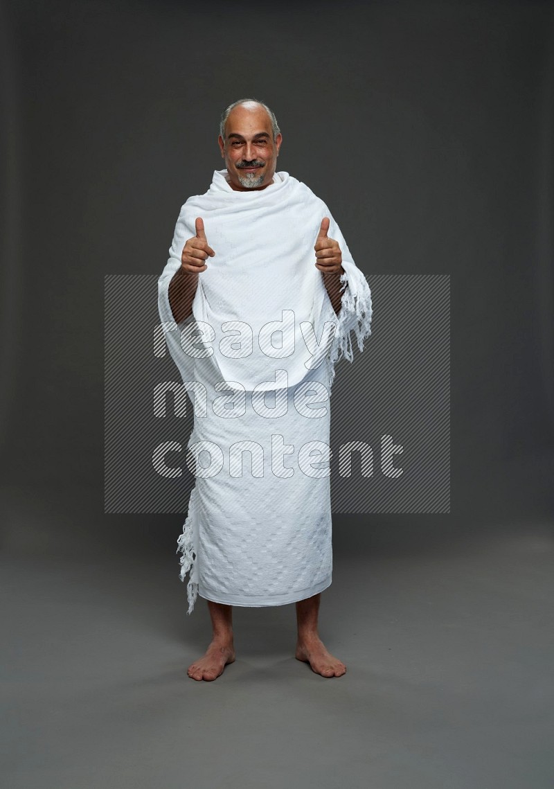 A man wearing Ehram Standing Interacting with the camera on gray background