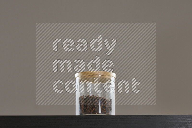 Dried basil in a glass jar on black background