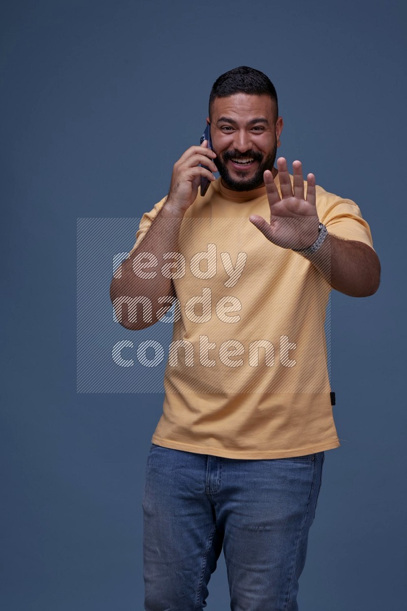 A man Calling on Blue Background wearing Orange T-shirt