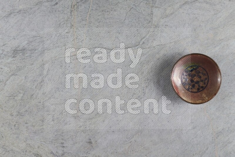 صحن فخاري مزخرف على خلفية من الرخام الرمادي