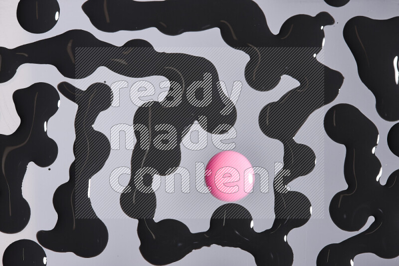 Close-ups of abstract pink and black paint droplets on the surface