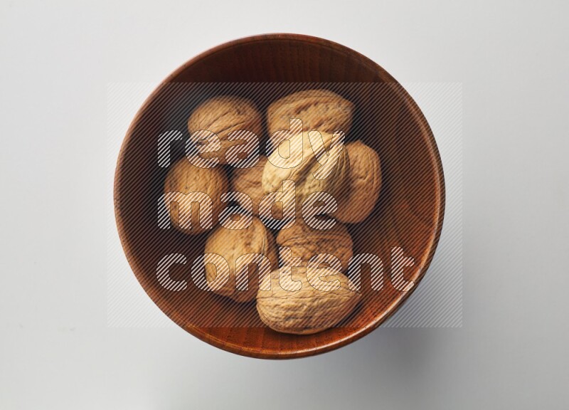 Top-view shot of walnut in a container on white background