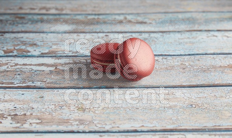 45º Shot of two Red Velvet macarons on light blue wooden background