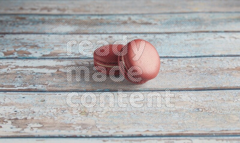 45º Shot of two Red Velvet macarons on light blue wooden background