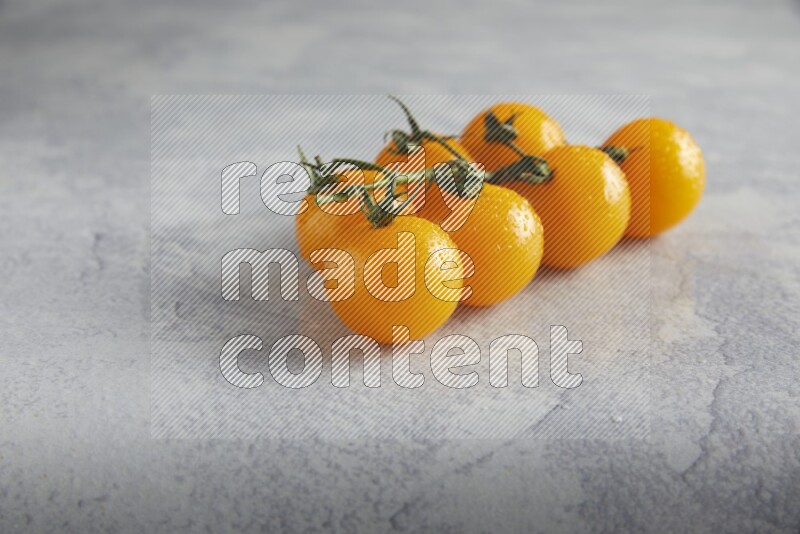 Yellow cherry tomato vein on a light grey textured background 45 degree