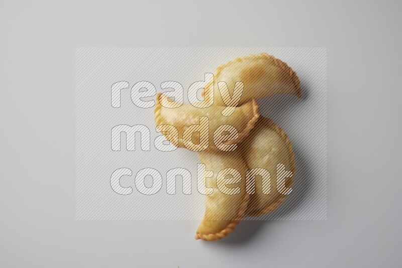 Four fried sambosa from a top angle on a white background