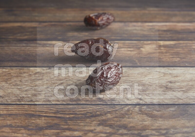 three madjoul dates on a wooden background