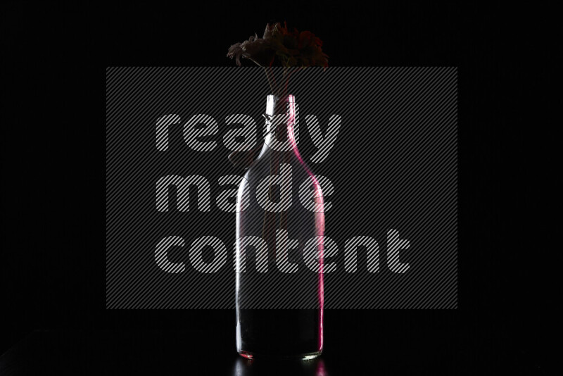 Water bottle with colored rim light against black background