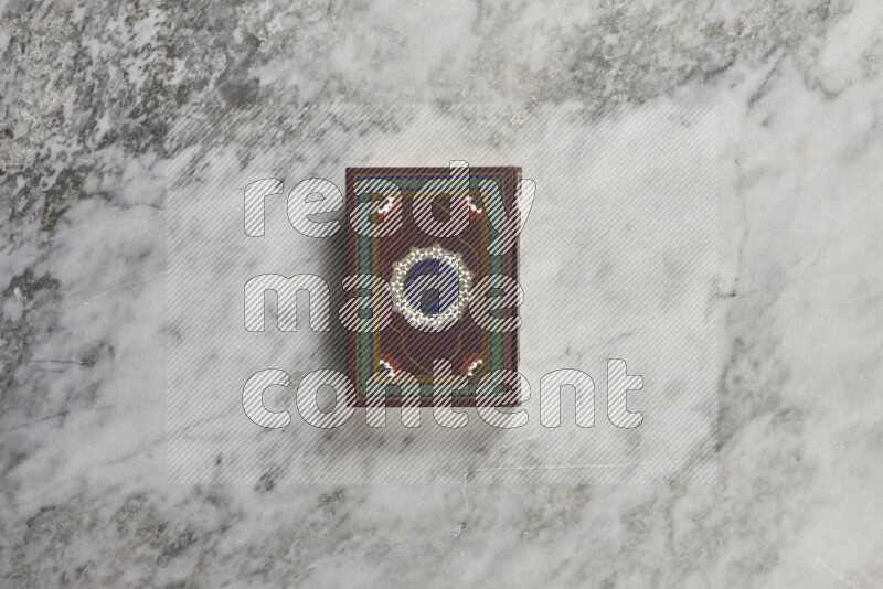 Quran with a prayer beads on grey marble background