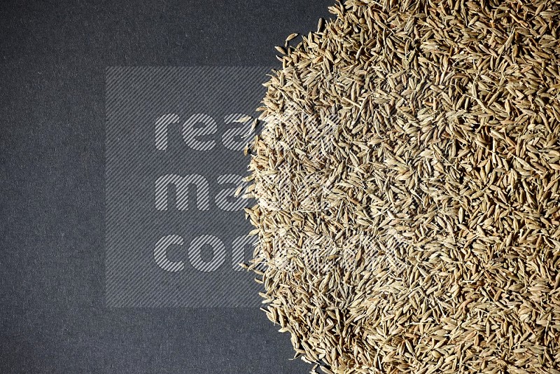 Cumin seeds on black flooring