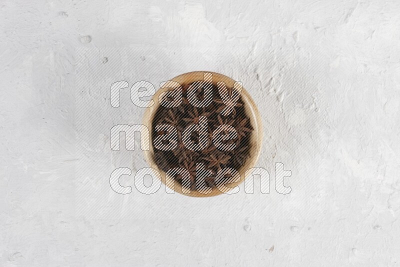 Star Anise in a wooden bowl on white flooring