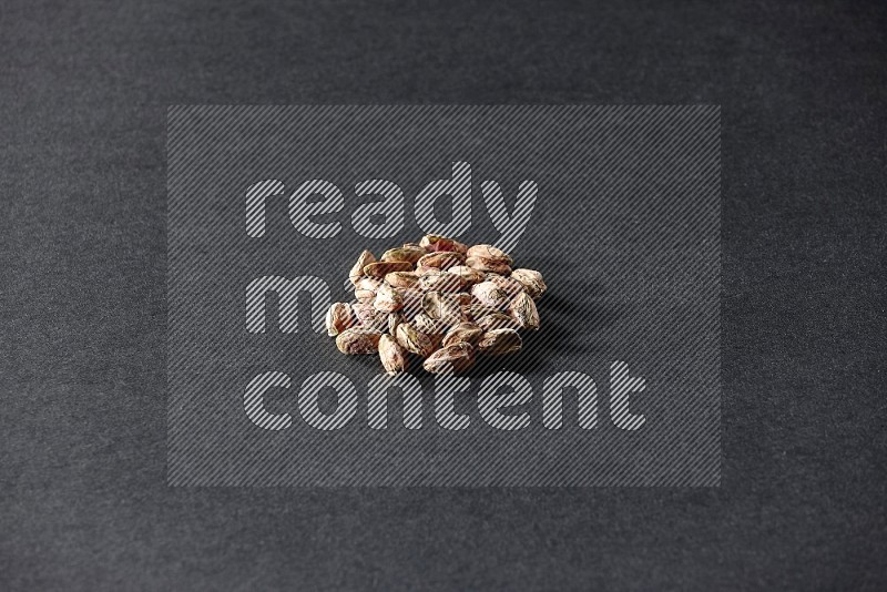 A bunch of peeled pistachios on a black background in different angles