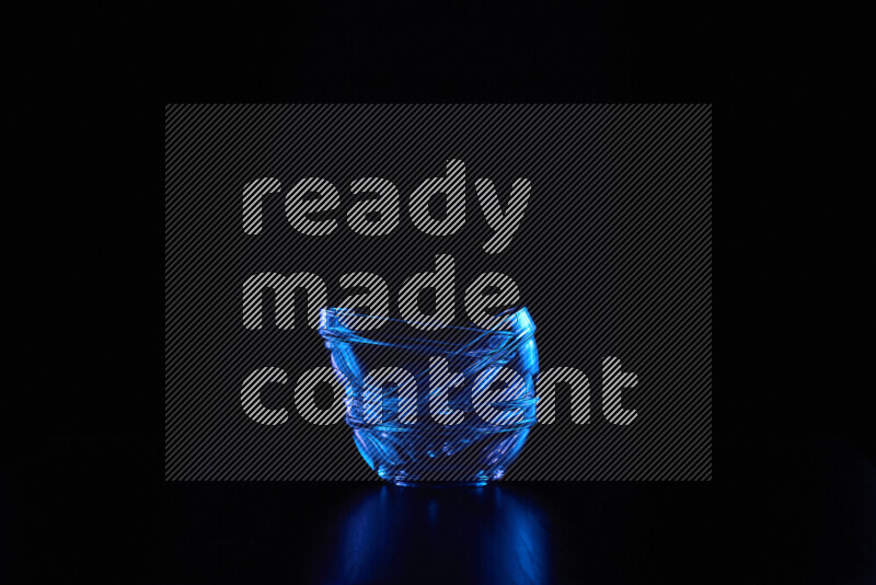 Glassware with rim light in blue against black background