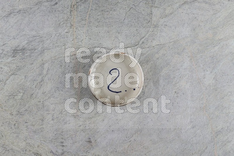 Top View Shot Of A Multicolored Pottery Bowl On Grey Marble Flooring