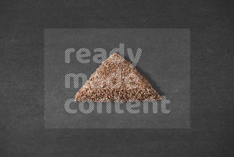 Flax Seeds in a triangle shape on a black Flooring