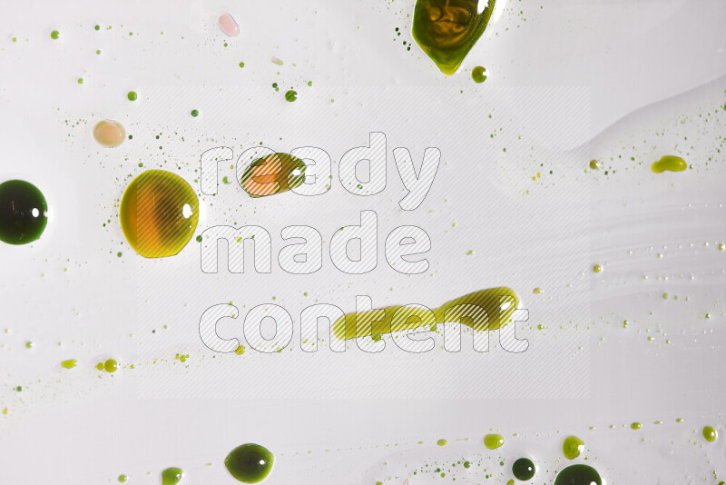 Close-ups of abstract yellow and green paint droplets on the surface