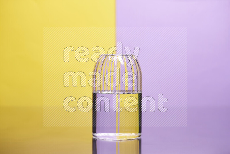 The image features a clear glassware filled with water, set against yellow and light purple background