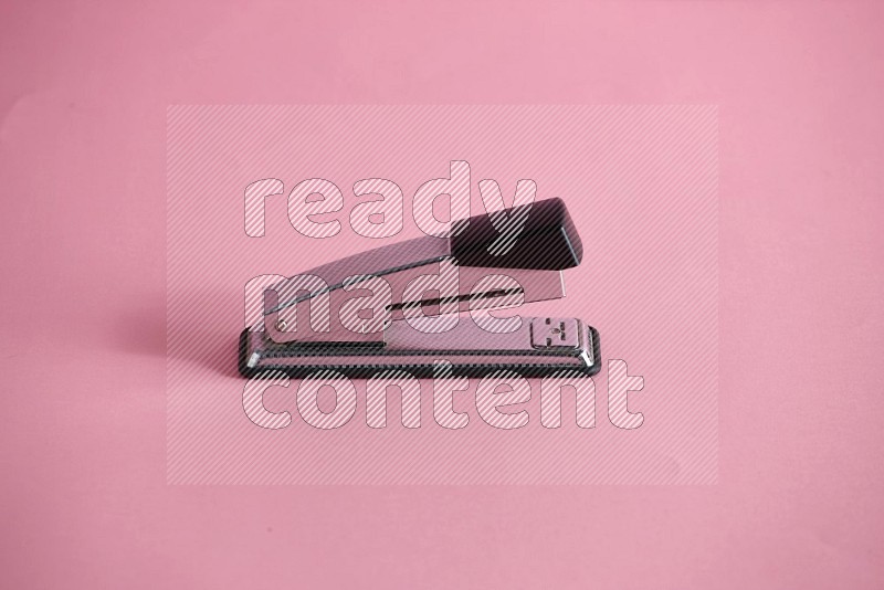 A metal stapler on rose background in different  angles (back to school)