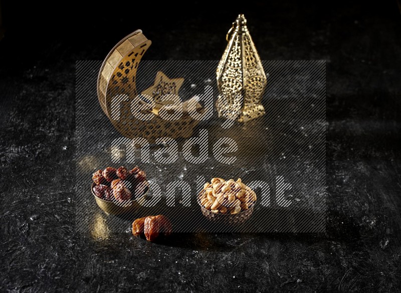 Dates in a metal bowl with cashews beside golden lanterns in a dark setup