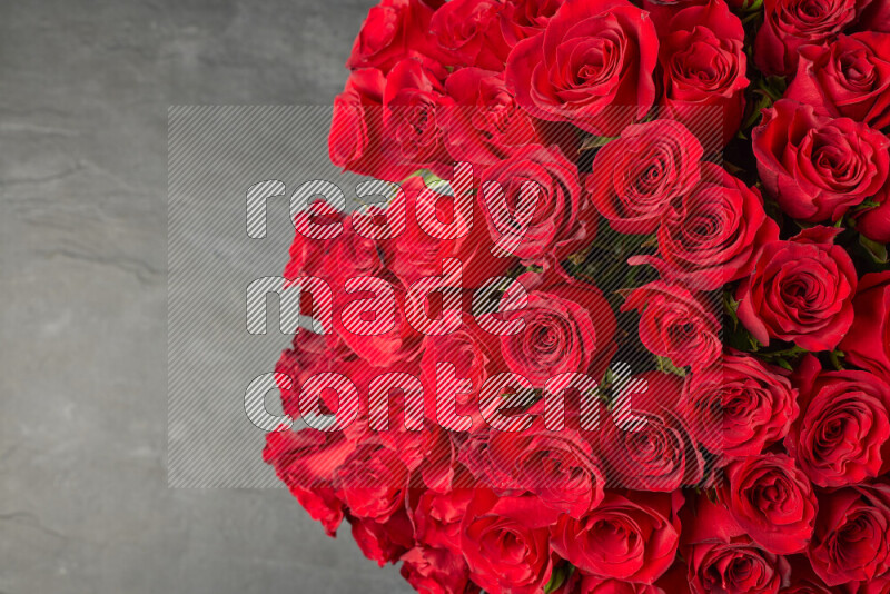 A luxurious bouquet of red roses on black marble background
