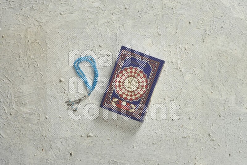 Quran with a prayer beads on white background