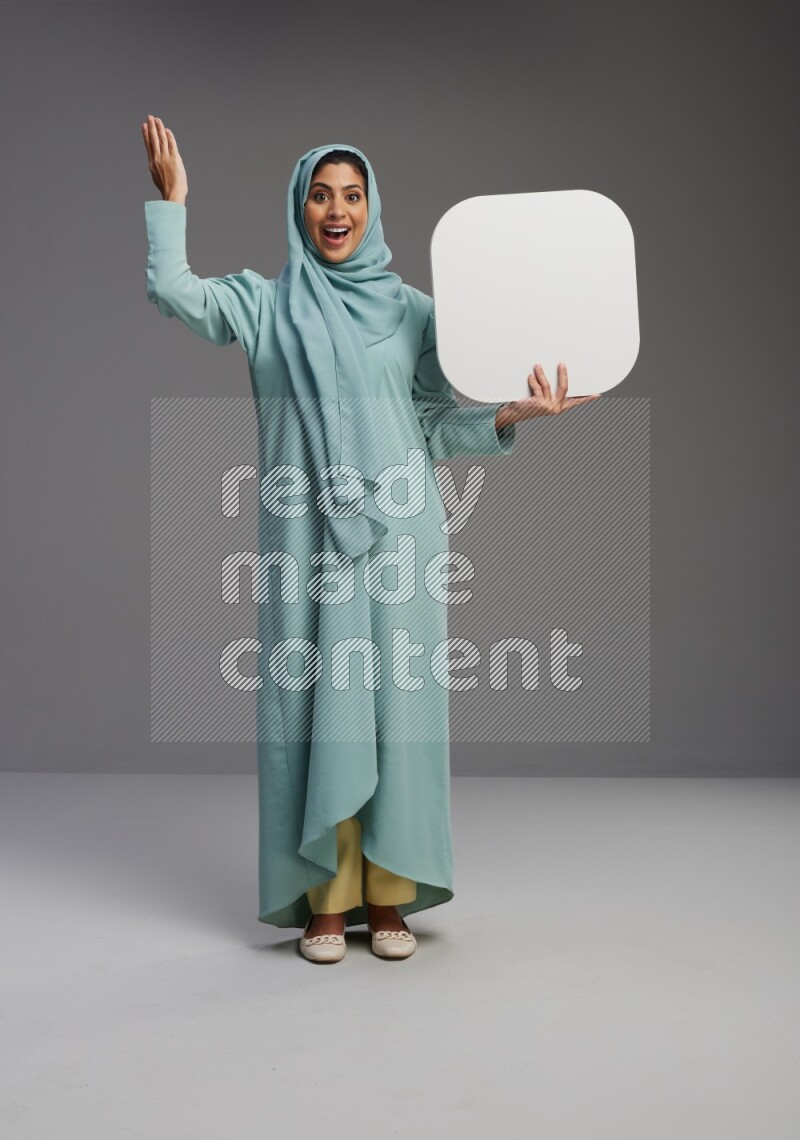 Saudi Woman wearing Abaya standing holding social media sign on Gray background
