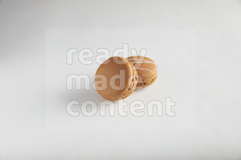 45º Shot of of two assorted Brown Irish Cream, and Brown Maple Taffy macarons  on white background