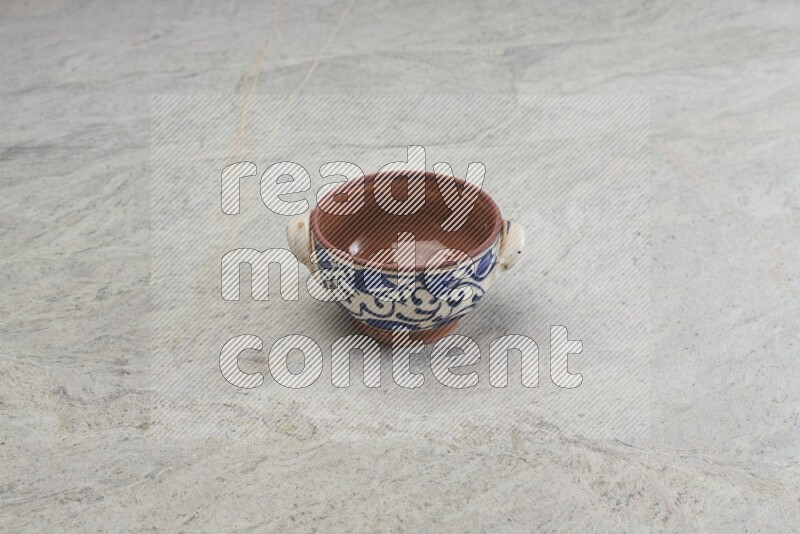 A multicolored pottery bowl on grey marble background