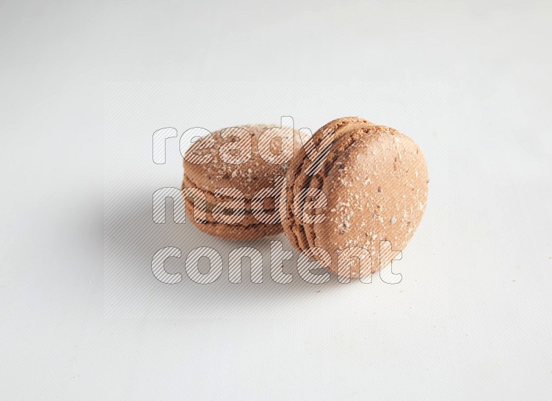 45º Shot of two Brown Hazelnuts macarons on white background