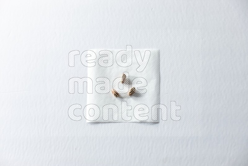 3 peeled pistachios on a piece of paper on a white background in different angles