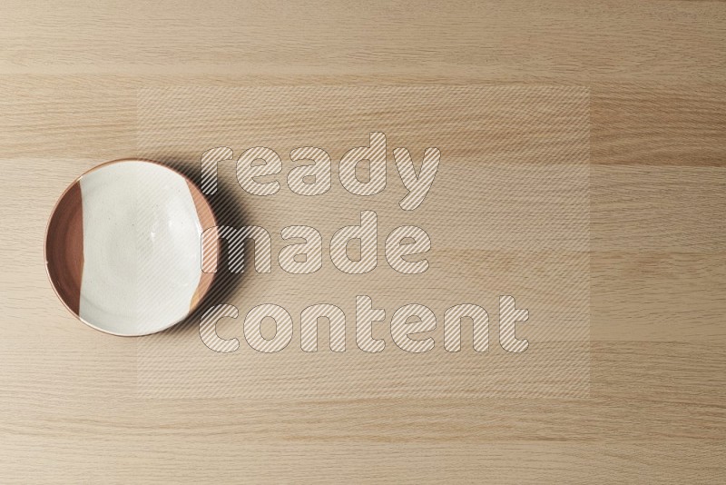 Top View Shot Of A Multicolored Pottery Plate on Oak Wooden Flooring