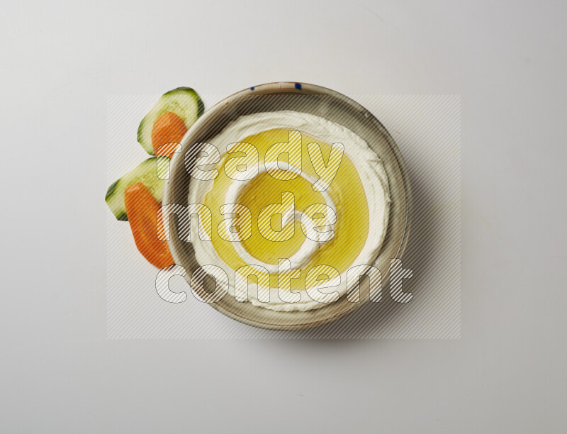 Lebnah garnished with olive oil in a grey pottery plate on a white background
